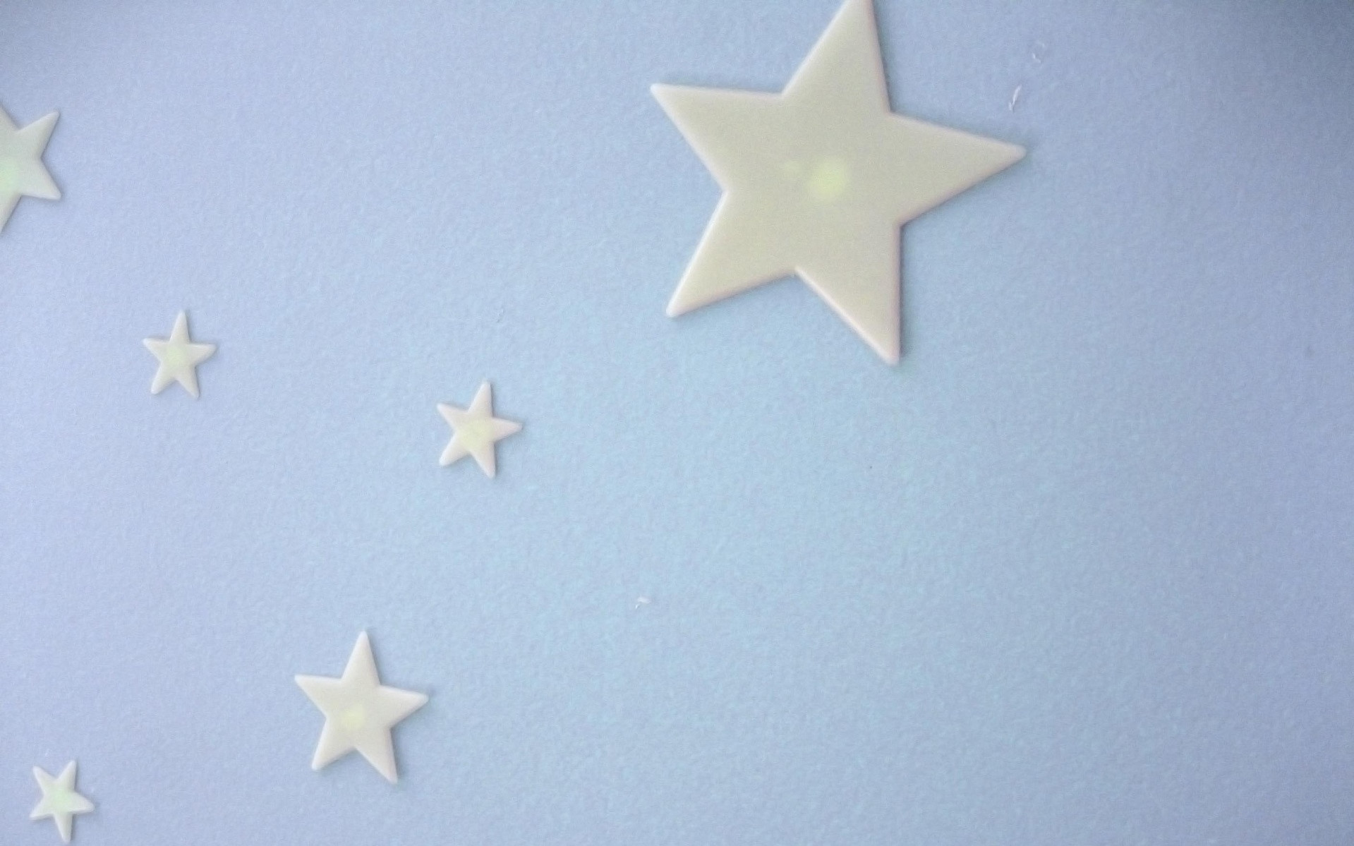 Image: A series of glow in the dark stars on a wall.