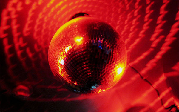 Image: A discoball in red lighting.