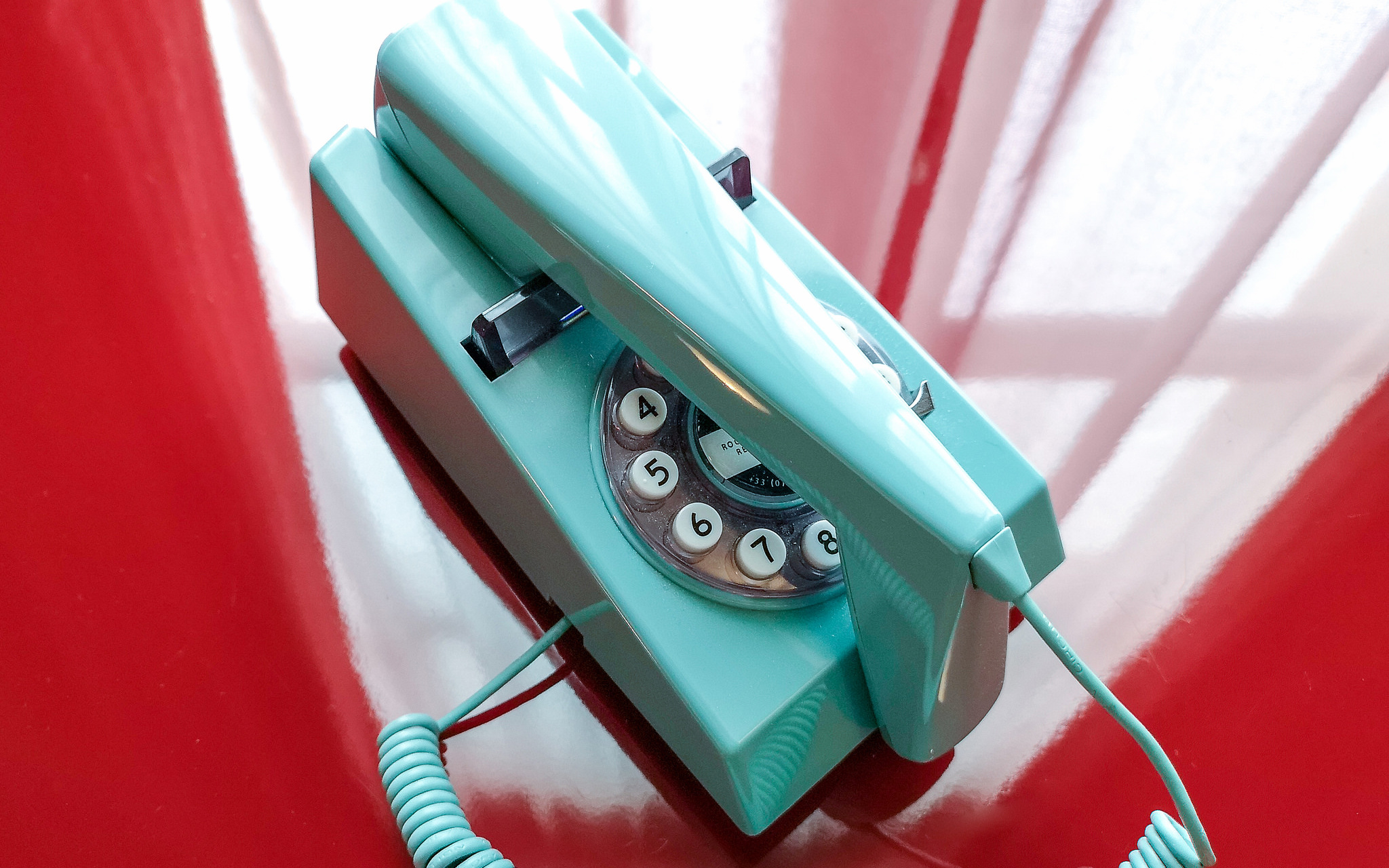 Image: A blue telephone upon a red table. "Telephone" by GillyBerlin is licensed under CC BY 2.0