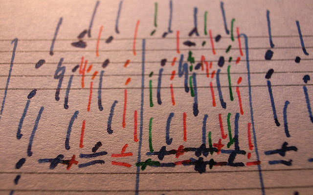 Image: A sheet of music written in colored ink.