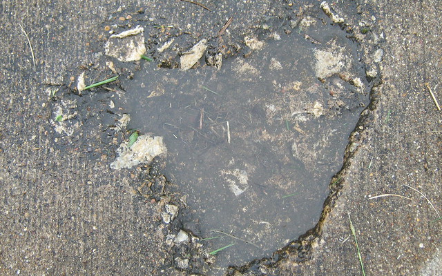 Image: A pothole in a sidewalk.