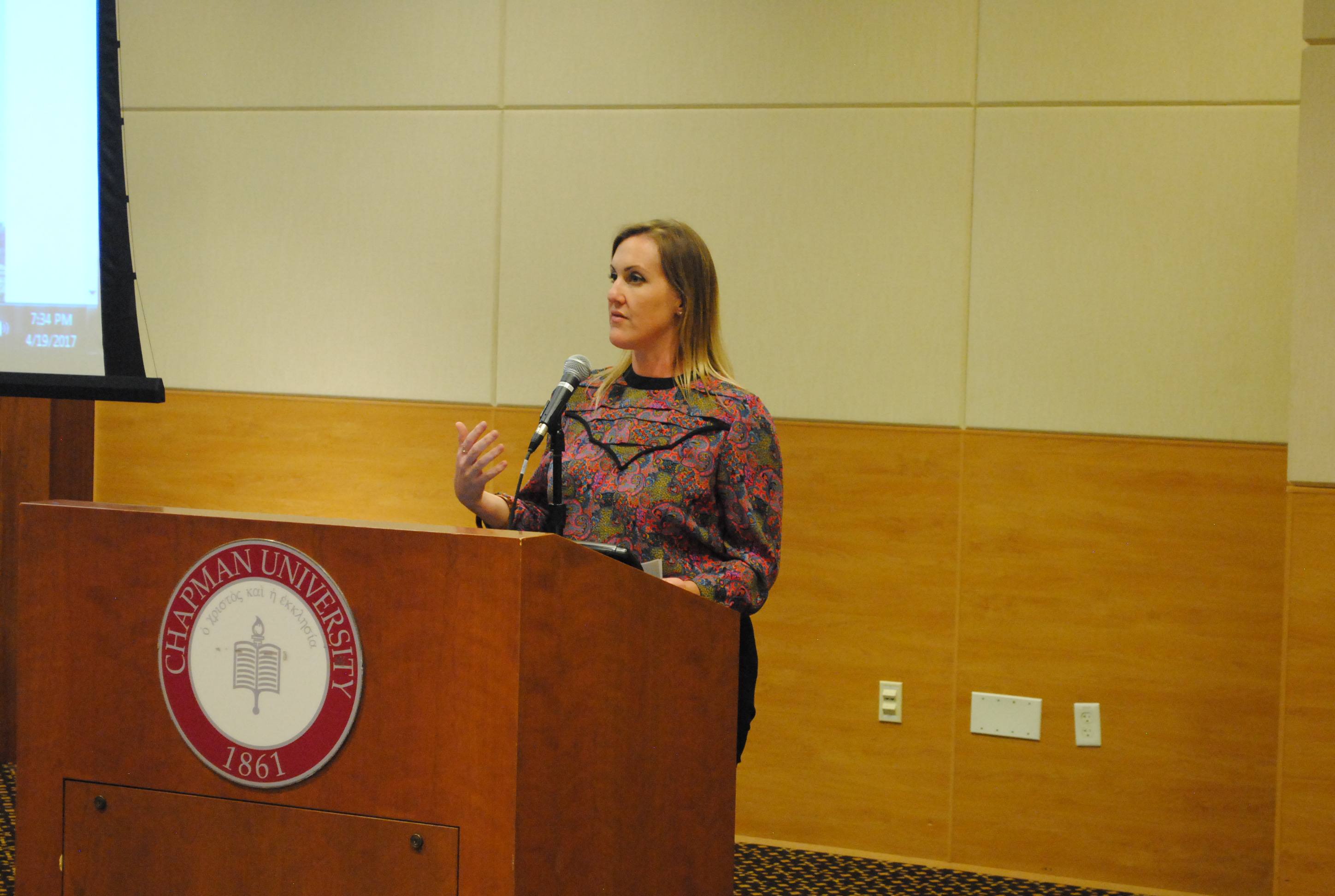 Image: Alison Williams speaking at Chapman University podium.
