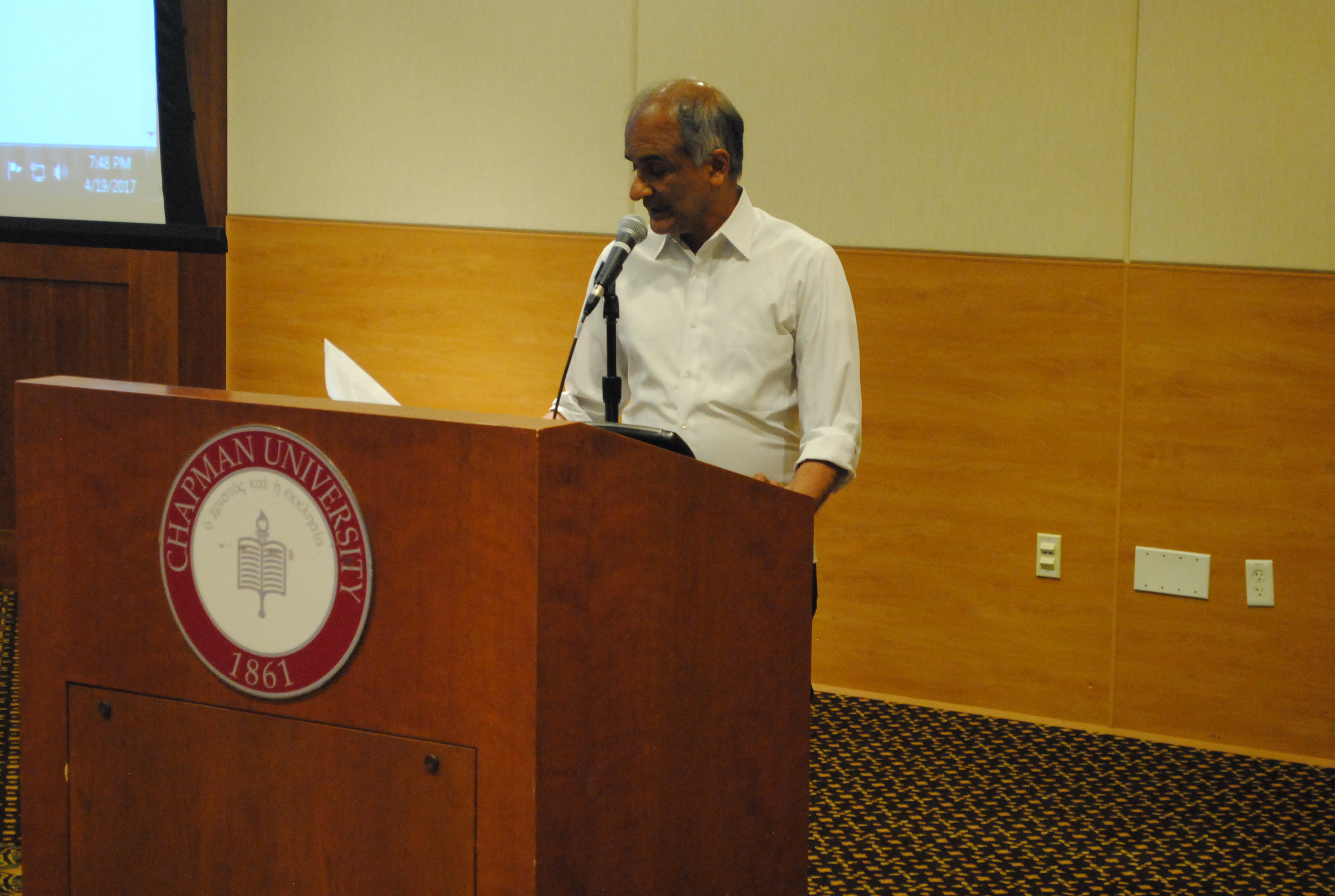 Image; Man at Chapman University podium reading.