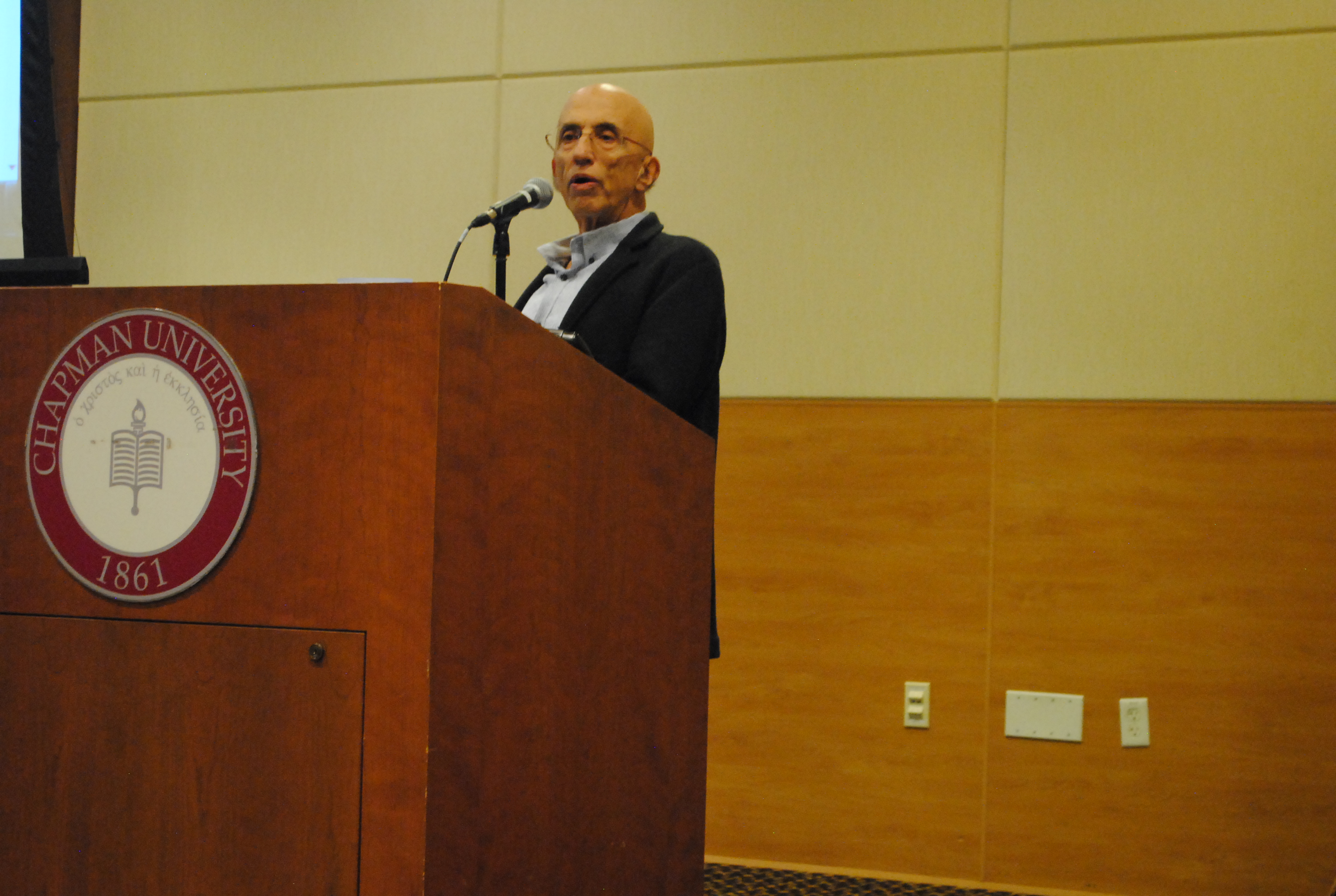 Image: Man speaking at Chapman University podium.