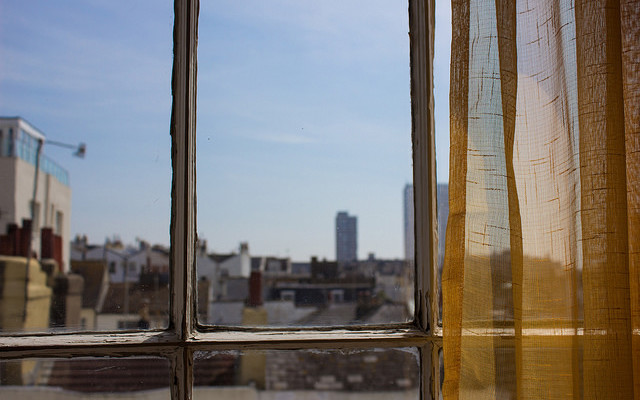 Image: A city skyline seen through a window.